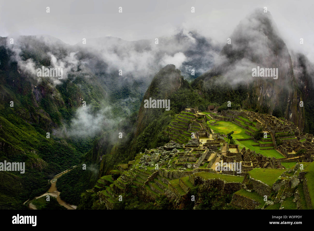 Ampio angolo di fotografia di Machu Picchu parzialmente coperto le nuvole. Foto Stock