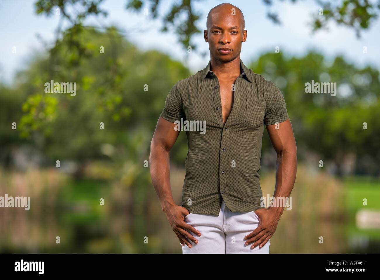 Foto di un bel giovane americano africano modello maschile in posa con le mani nelle tasche Foto Stock