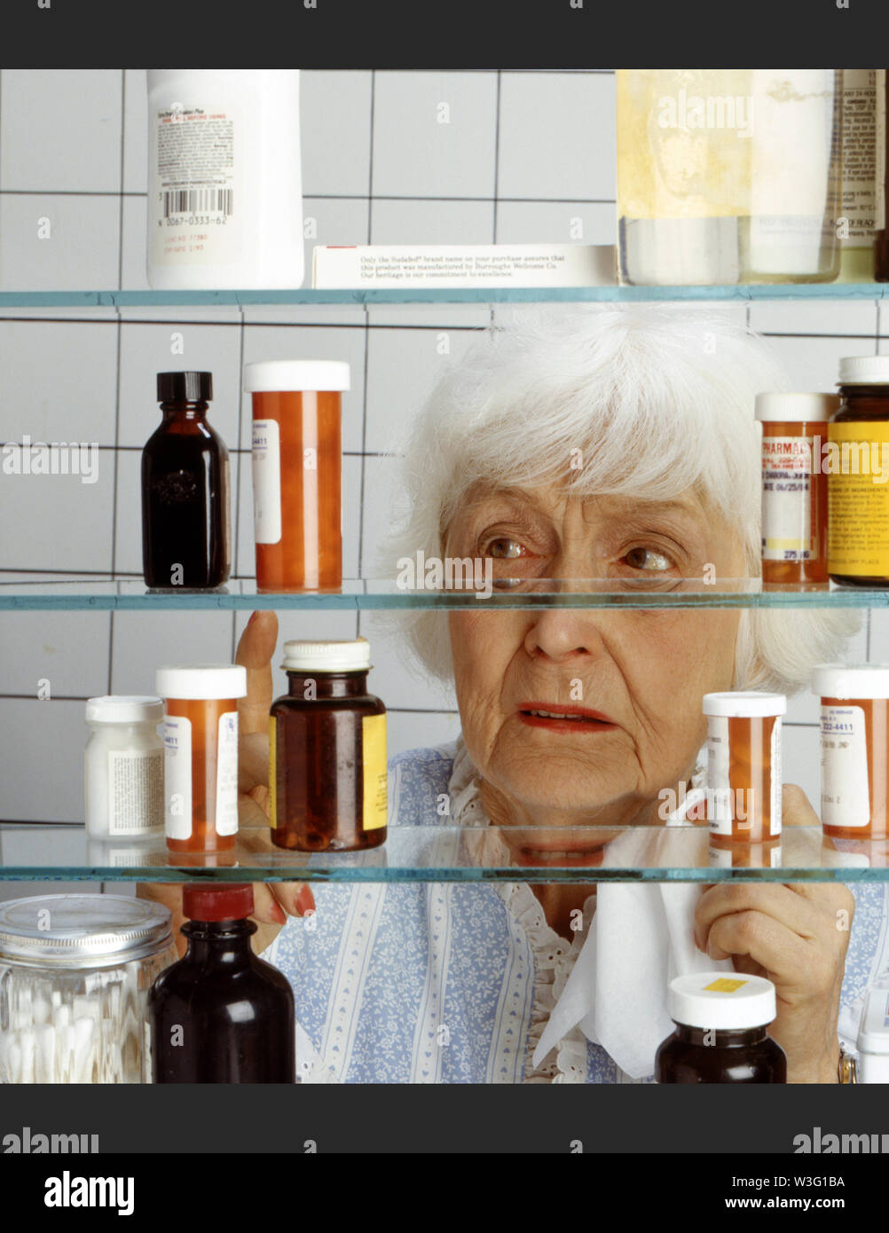 Vecchia Signora contemplando farmaco Foto Stock