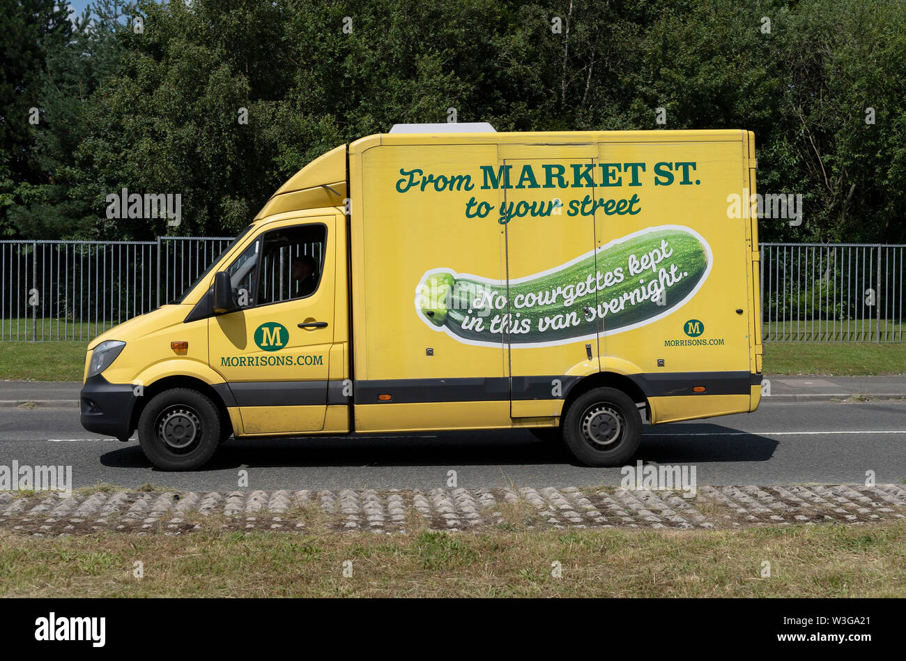 Un supermercato Morrisons furgone è guidata su una tranquilla strada urbana (solo uso editoriale). Foto Stock