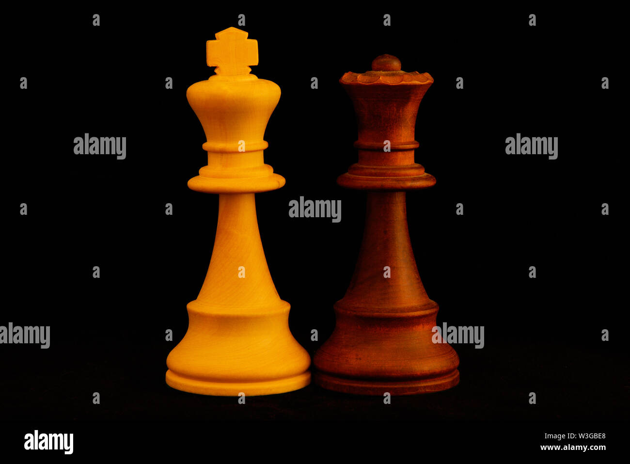 Re bianco, regina nera come coppia mista concetto.Standard del gioco degli scacchi pezzi di legno su sfondo nero Foto Stock