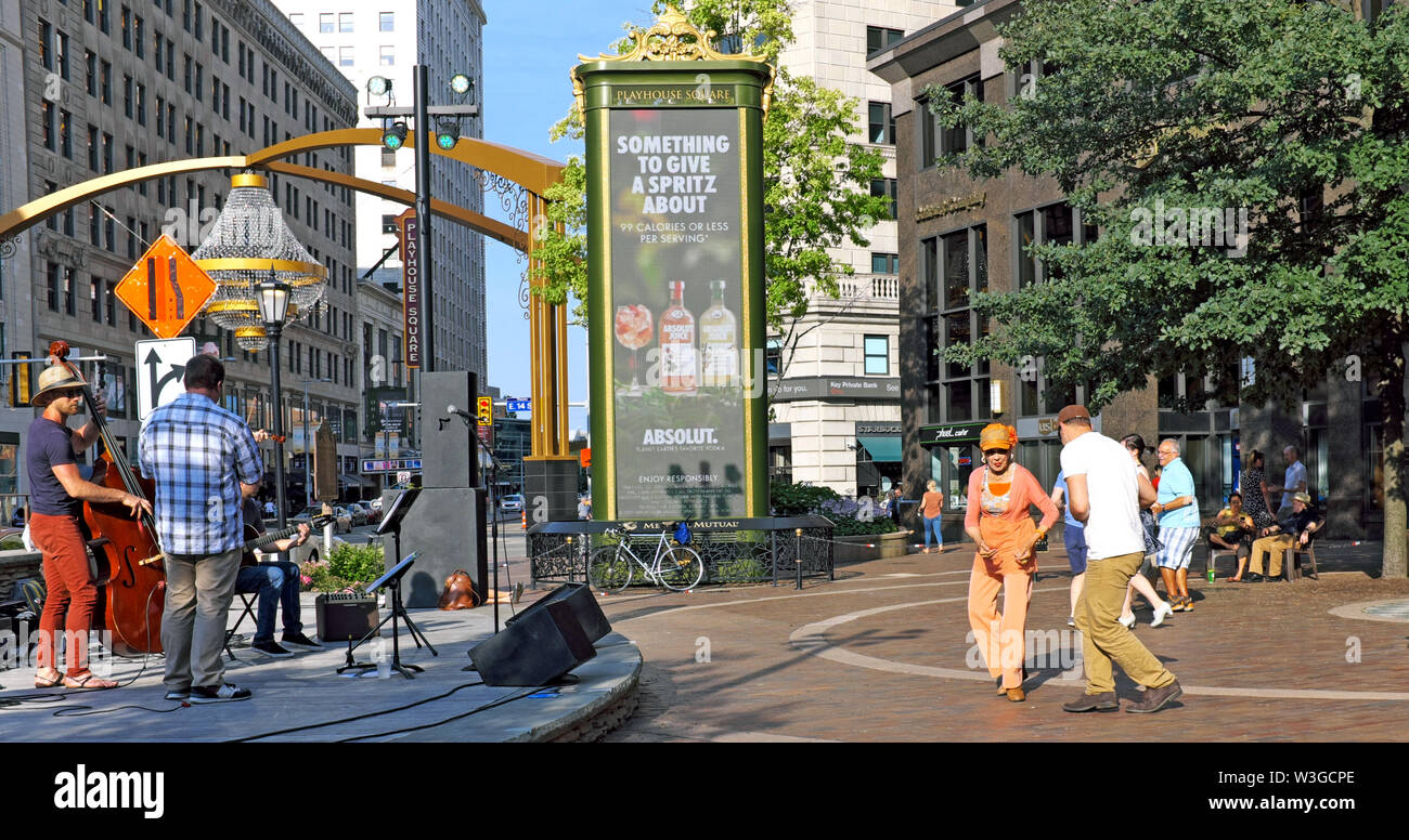 Le persone ballano con una band dal vivo all'aperto nello U.S. Bank Plaza durante il programma settimanale "Dancing Under the Stars" a Playhouse Square, Cleveland, Ohio. Foto Stock