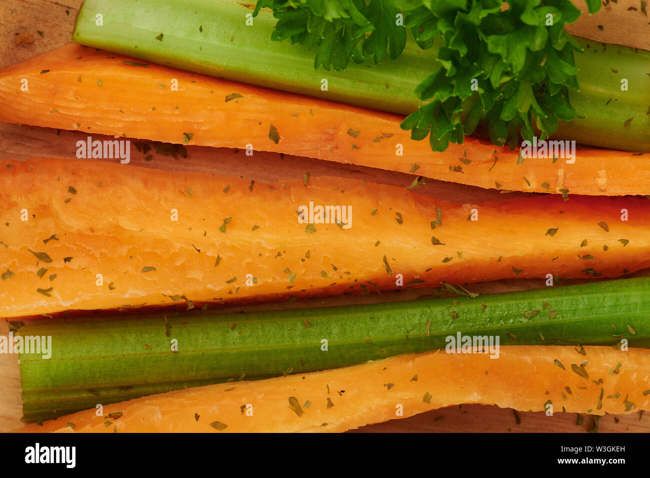 Freschi fette di carote e sedano con le erbe su sfondo di legno Foto Stock