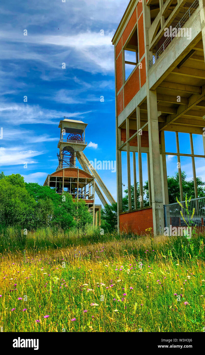 In disuso di una miniera di carbone della miniera di ingranaggio di avvolgimento di un vecchio carbone belga il mio albero contro un cielo blu chiaro Foto Stock