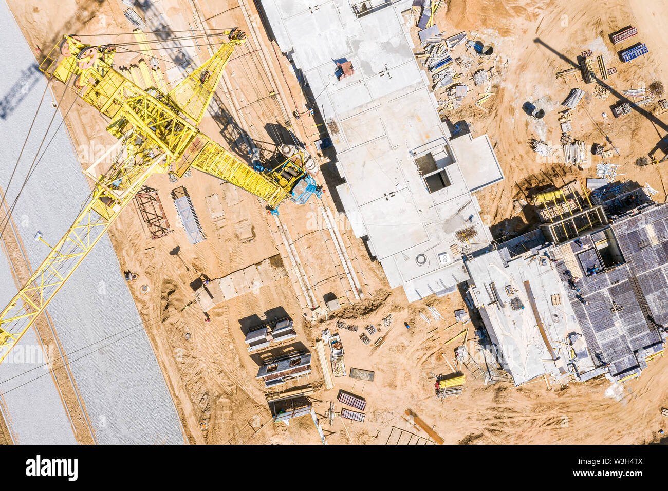 Vista superiore del giallo alta gru a torre permanente al sito in costruzione. drone immagine Foto Stock
