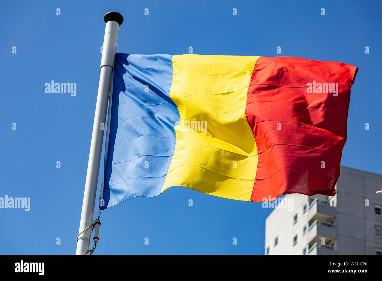 Bandiera della Romania, Rumeno simbolo nazionale sventolare contro il cielo blu chiaro, giornata di sole Foto Stock
