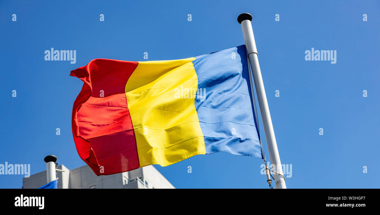 Bandiera della Romania, Rumeno simbolo nazionale sventolare contro il cielo blu chiaro, giornata di sole Foto Stock