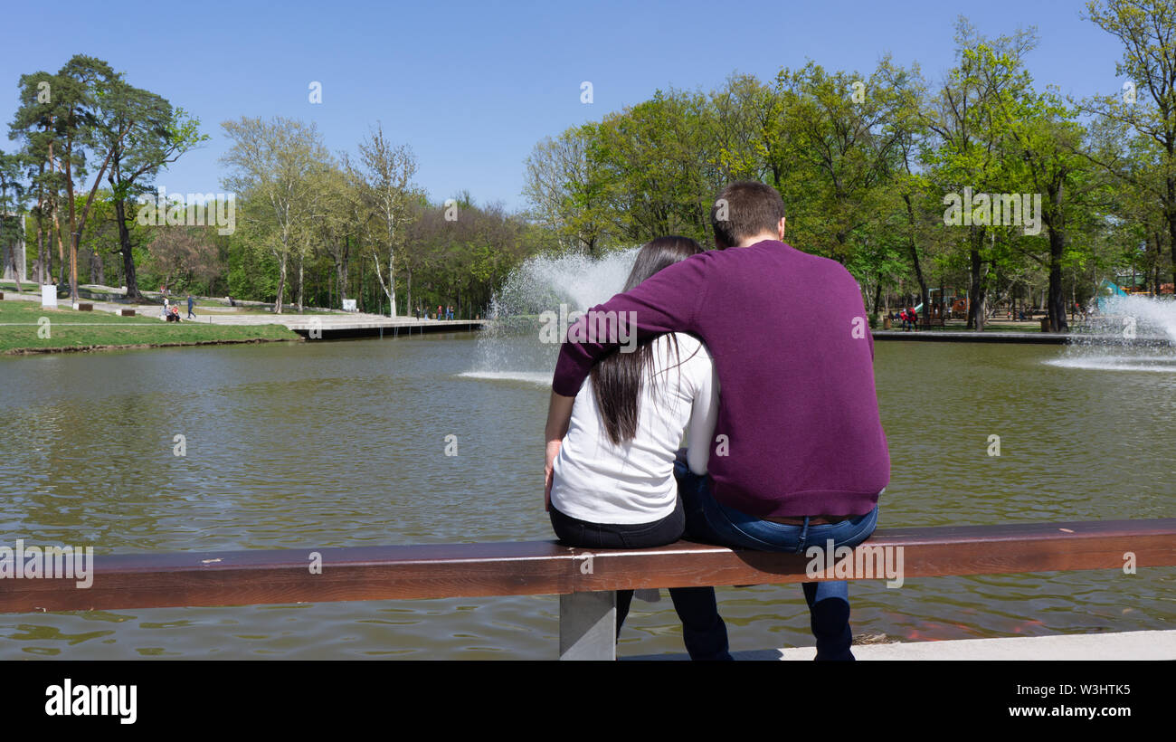 Debrecen Ungheria 04 19 2019 coppia giovane seduta su una panchina e guardando una fontana a Debrecen nel grande parco della foresta Foto Stock