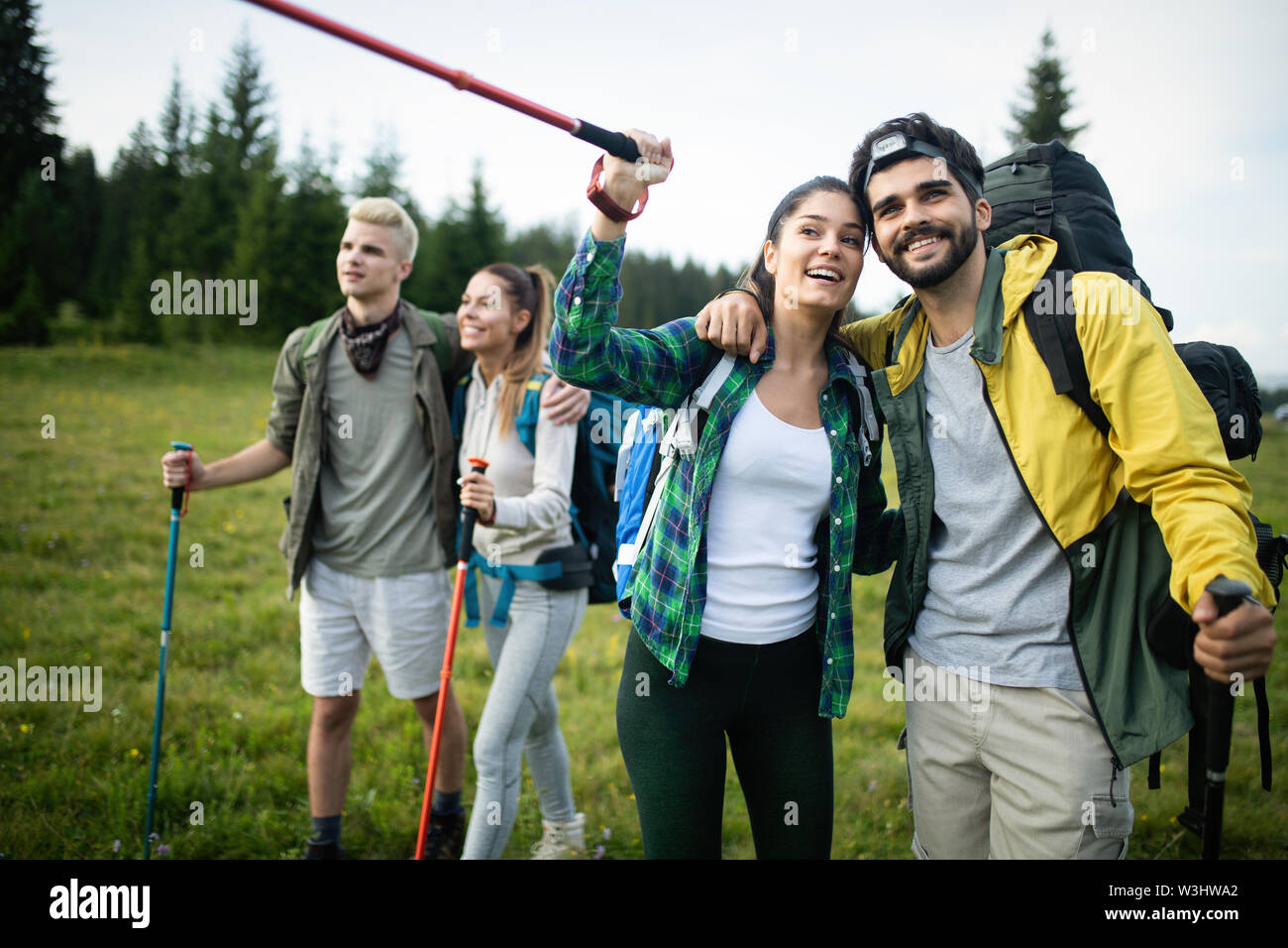 Giovani amici su un paese a piedi. Gruppo di persone passeggiate attraverso la campagna Foto Stock