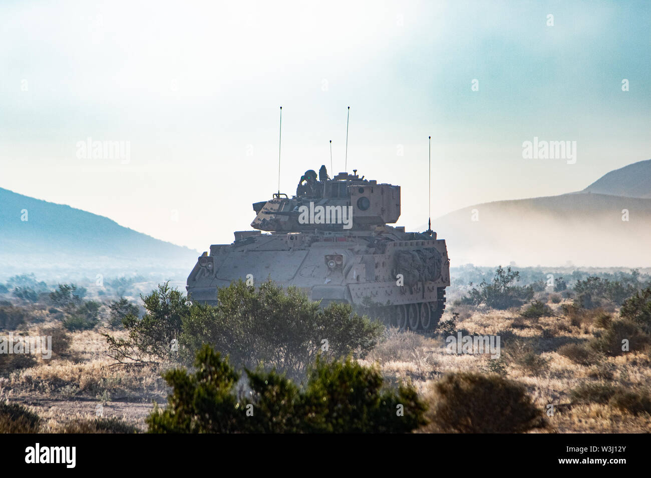 Trentesimo Armored vigili del Team di combattimento Bradley combattendo le scansioni del veicolo per il suo momento di opportunità per attaccare le forze contrapposte in Ujen formazione militare Village presso il Centro Nazionale di allenamento su Ft. Irwin, CA Luglio 14, 2019 come parte del funzionamento Hickory Sting. Bradley veicoli da combattimento sono parte del trentesimo ABCT's meccanizzata le forze di fanteria. Foto Stock