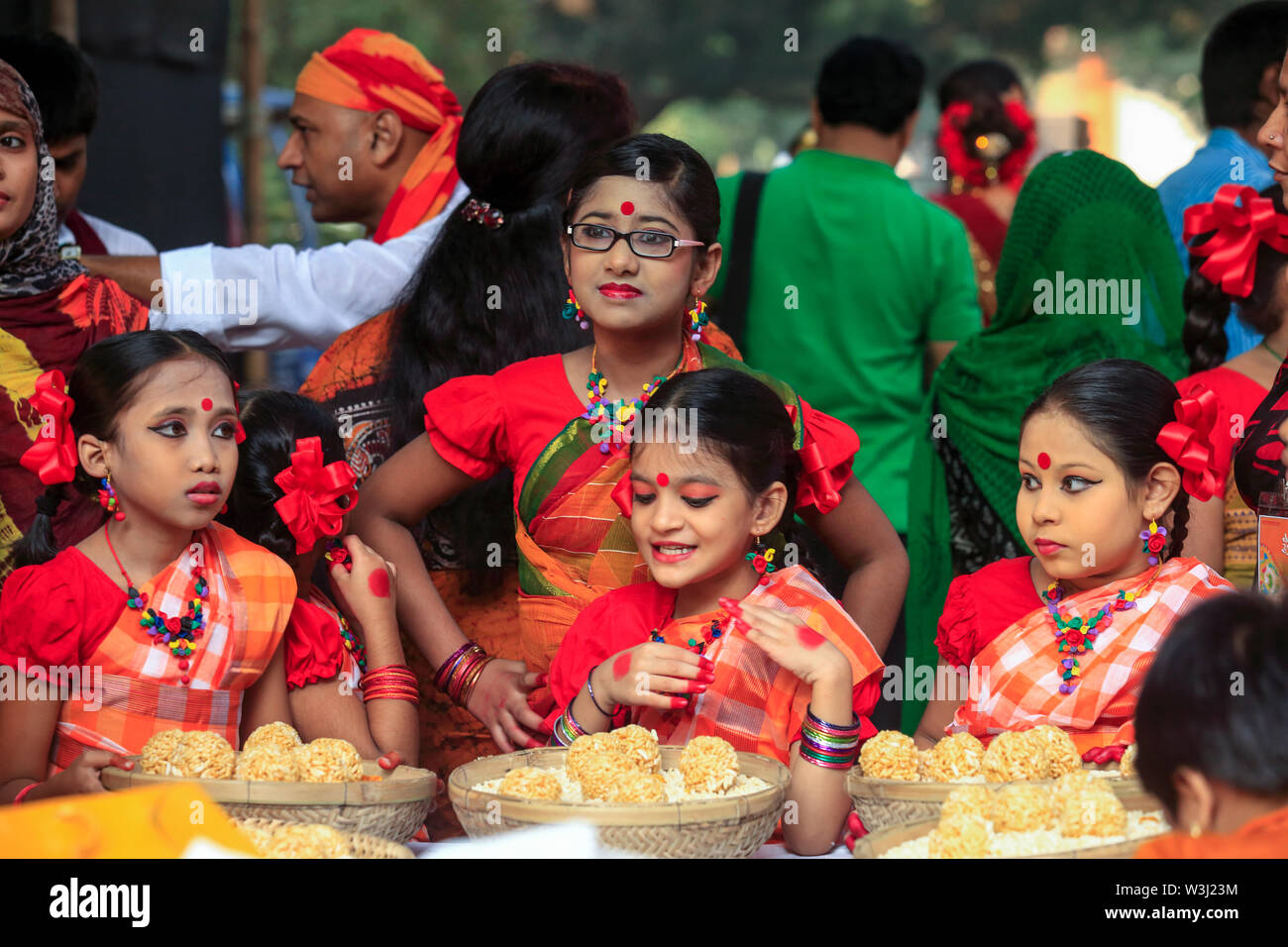 Giovani danzatori offrono i cesti di dolce tradizionale 'Moa' fatta di riso soffiato a 'Nabanna Utsab', il bengali harvest festival. Dacca in Bangladesh Foto Stock