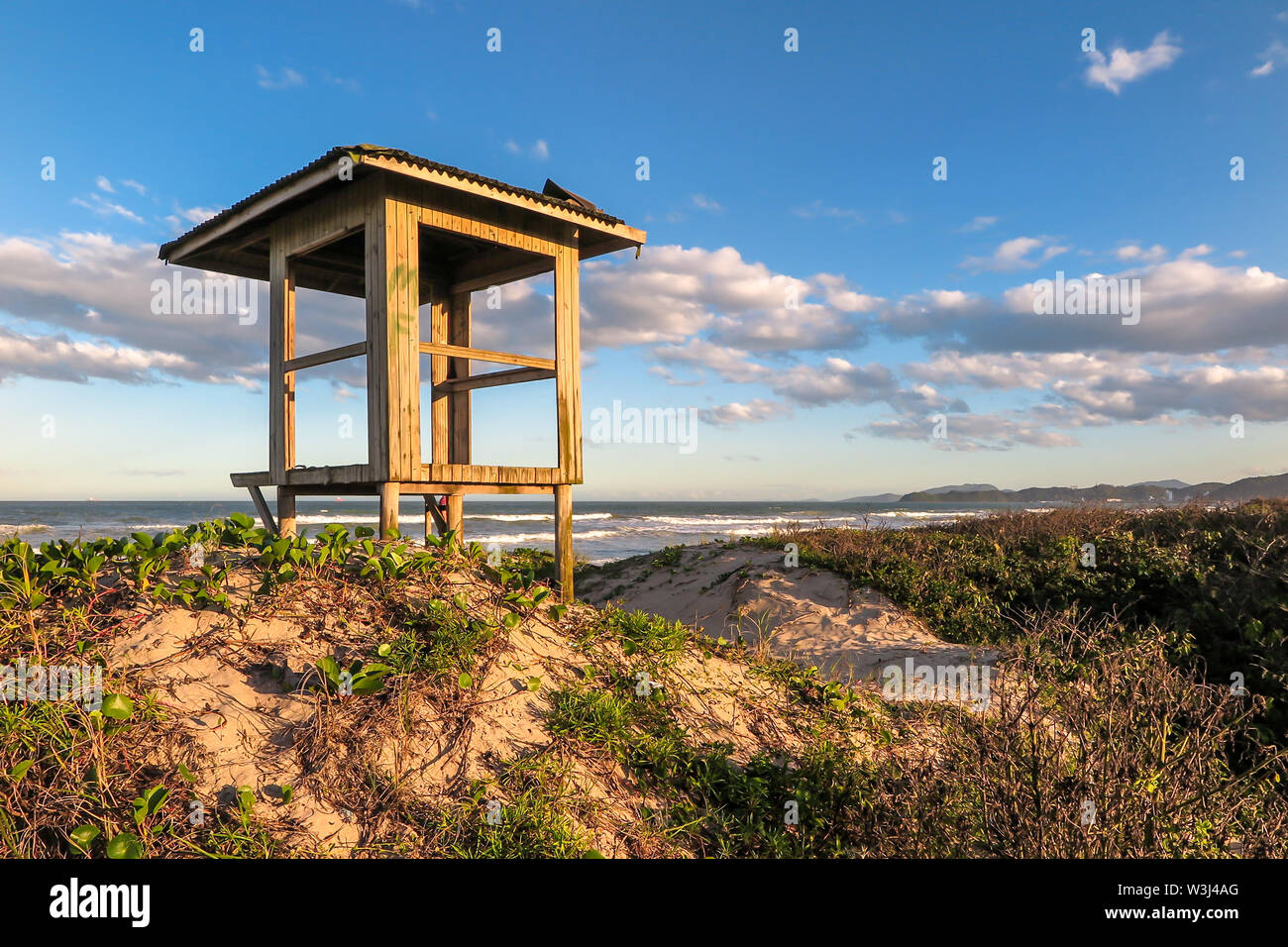 Bagnino capanna sulla spiaggia Navegantes nel tardo pomeriggio, con dune e vegetazione nativa, cielo blu con nuvole, Navegantes, Santa Catarina Foto Stock