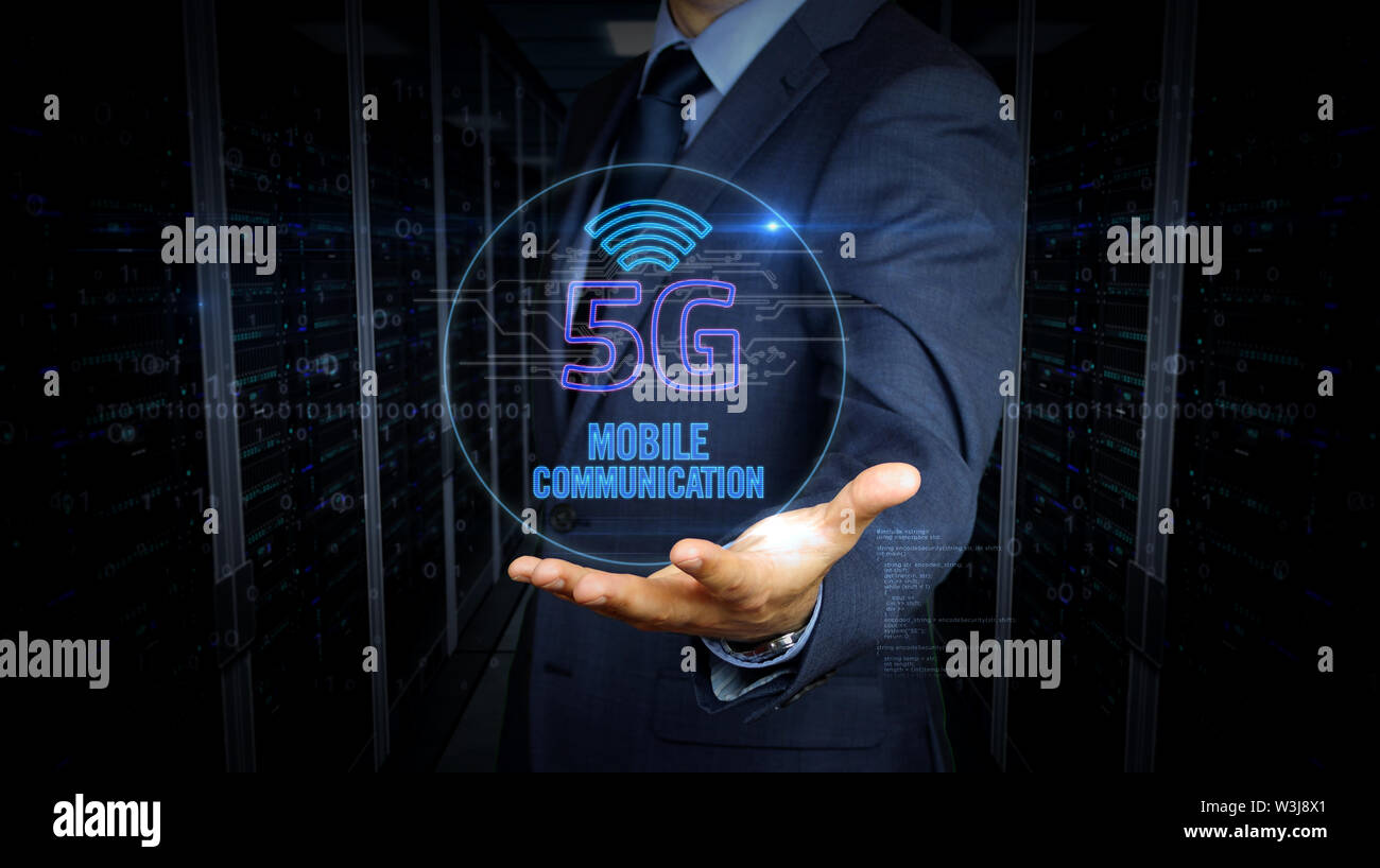 Un imprenditore in un vestito e lo schermo con 5G ologramma. Uomo con mano sul display virtuale di interfaccia. Rete wireless, la comunicazione mobile, dati tra Foto Stock