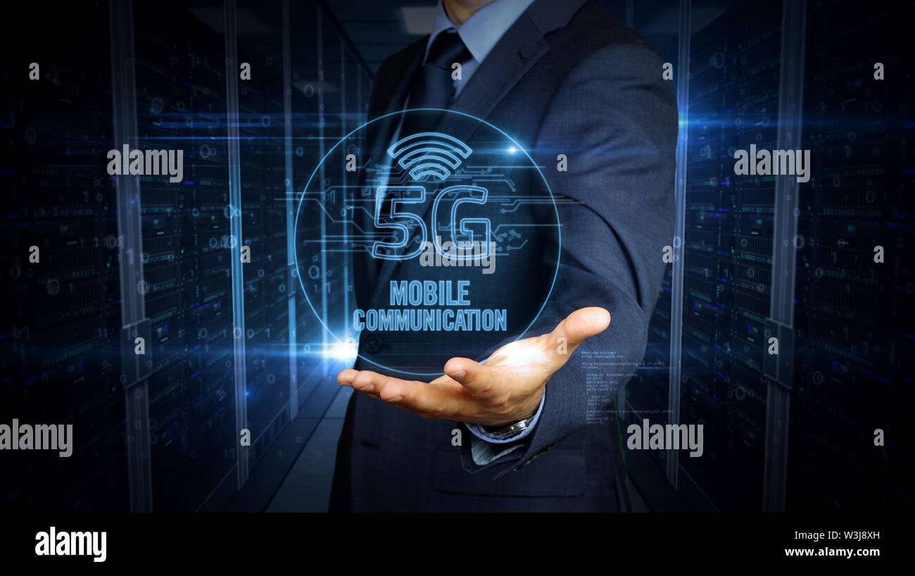 Un imprenditore in un vestito e lo schermo con 5G ologramma. Uomo con mano sul display virtuale di interfaccia. Rete wireless, la comunicazione mobile, dati tra Foto Stock
