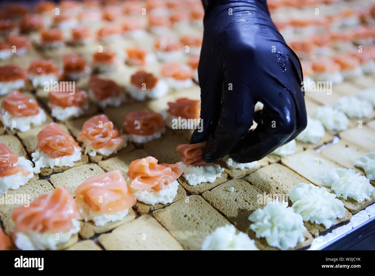Lo Chef rendendo norvegesi di salmone affumicato tartine con crema di formaggio Foto Stock
