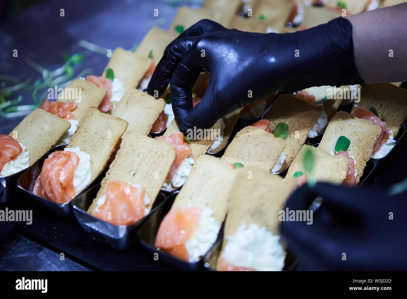 Lo Chef rendendo norvegesi di salmone affumicato tartine con crema di formaggio Foto Stock