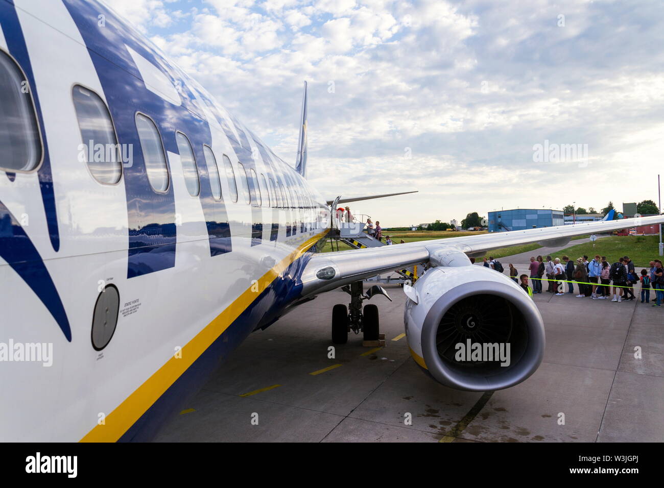 MEMMINGEN, Germania - 6 Luglio 2019: persone imbarco irlandese Ryanair compagnia aerea low-cost aereo Boeing 737 con sfondo con cielo nuvoloso su luglio 6, 2019 in Memmin Foto Stock