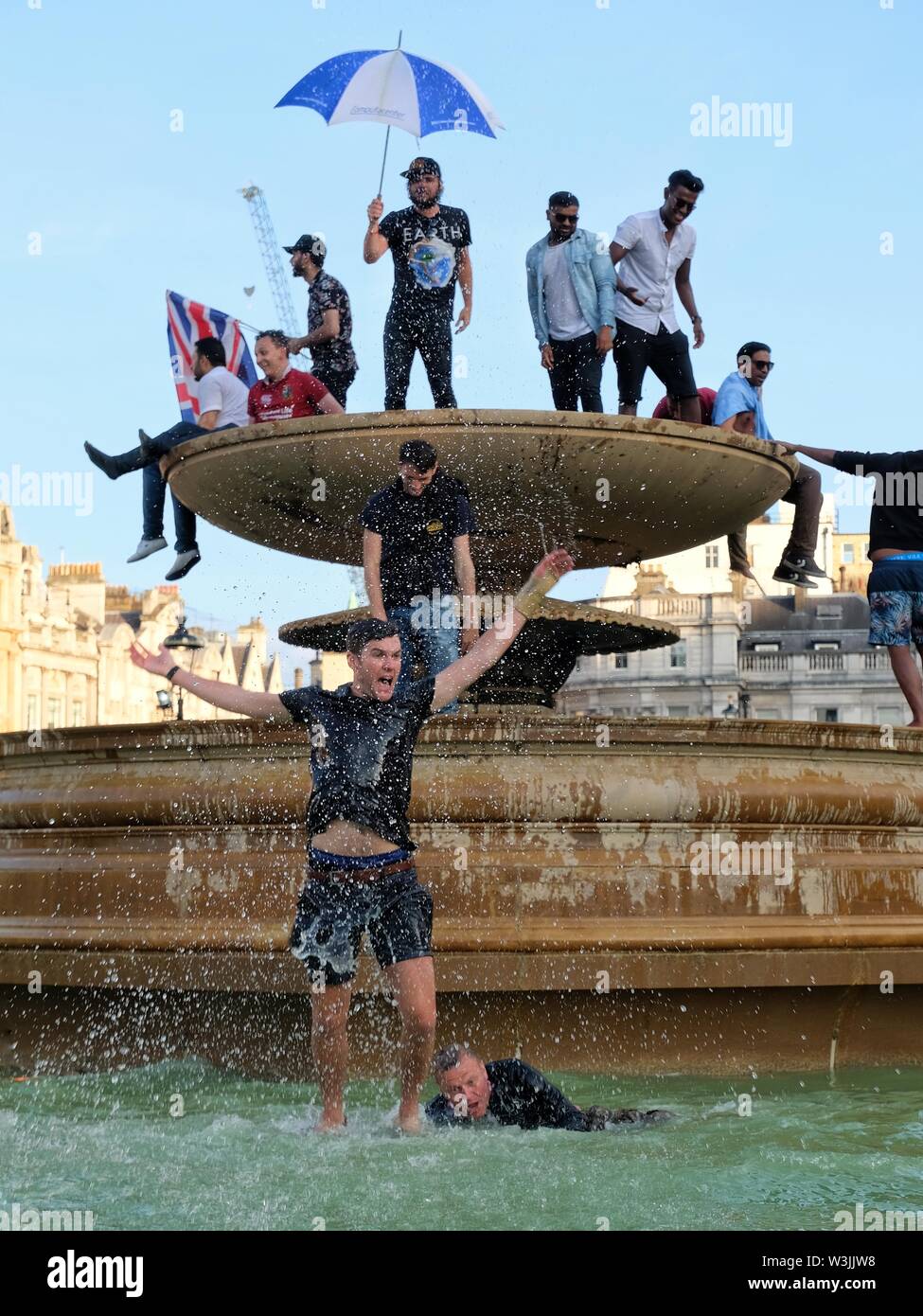 Tifosi di cricket celebrare l'Inghilterra del vittoria in Coppa del Mondo in Trafalgar Square di fontane e uomo salti di gioia Foto Stock