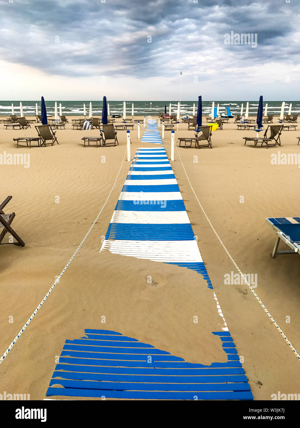 Spiaggia senza persone con ombrelli chiuso e il cattivo tempo Foto Stock
