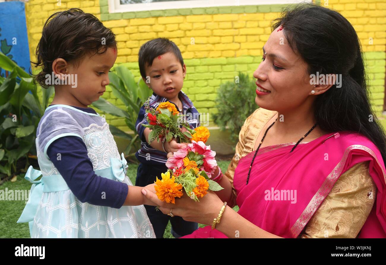 Kathmandu, Nepal. 16 Luglio, 2019. I bambini della scuola di offrire fiori al loro insegnante durante la celebrazione degli insegnanti' giornata presso una scuola locale a Kathmandu, Nepal, 16 luglio 2019. Teachers' giorno o Guru purnima festival è celebrato in tutto il paese il giorno di luna piena nel mese indù di Ashadha pagando riverenza a tutti gli insegnanti. Credito: Sunil Sharma/Xinhua/Alamy Live News Foto Stock