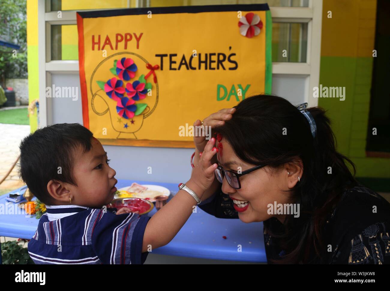 Kathmandu, Nepal. 16 Luglio, 2019. Una scuola per bambini offre red Tika su un insegnante di fronte come parte degli insegnanti' giorno celebrazione presso una scuola locale a Kathmandu, Nepal, 16 luglio 2019. Teachers' giorno o Guru purnima festival è celebrato in tutto il paese il giorno di luna piena nel mese indù di Ashadha pagando riverenza a tutti gli insegnanti. Credito: Sunil Sharma/Xinhua/Alamy Live News Foto Stock