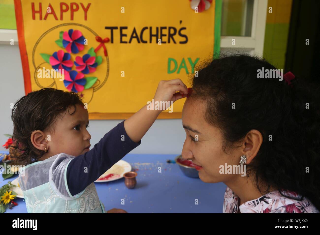 Kathmandu, Nepal. 16 Luglio, 2019. Una scuola per bambini offre red Tika su un insegnante di fronte come parte degli insegnanti' giorno celebrazione presso una scuola locale a Kathmandu, Nepal, 16 luglio 2019. Teachers' giorno o Guru purnima festival è celebrato in tutto il paese il giorno di luna piena nel mese indù di Ashadha pagando riverenza a tutti gli insegnanti. Credito: Sunil Sharma/Xinhua/Alamy Live News Foto Stock