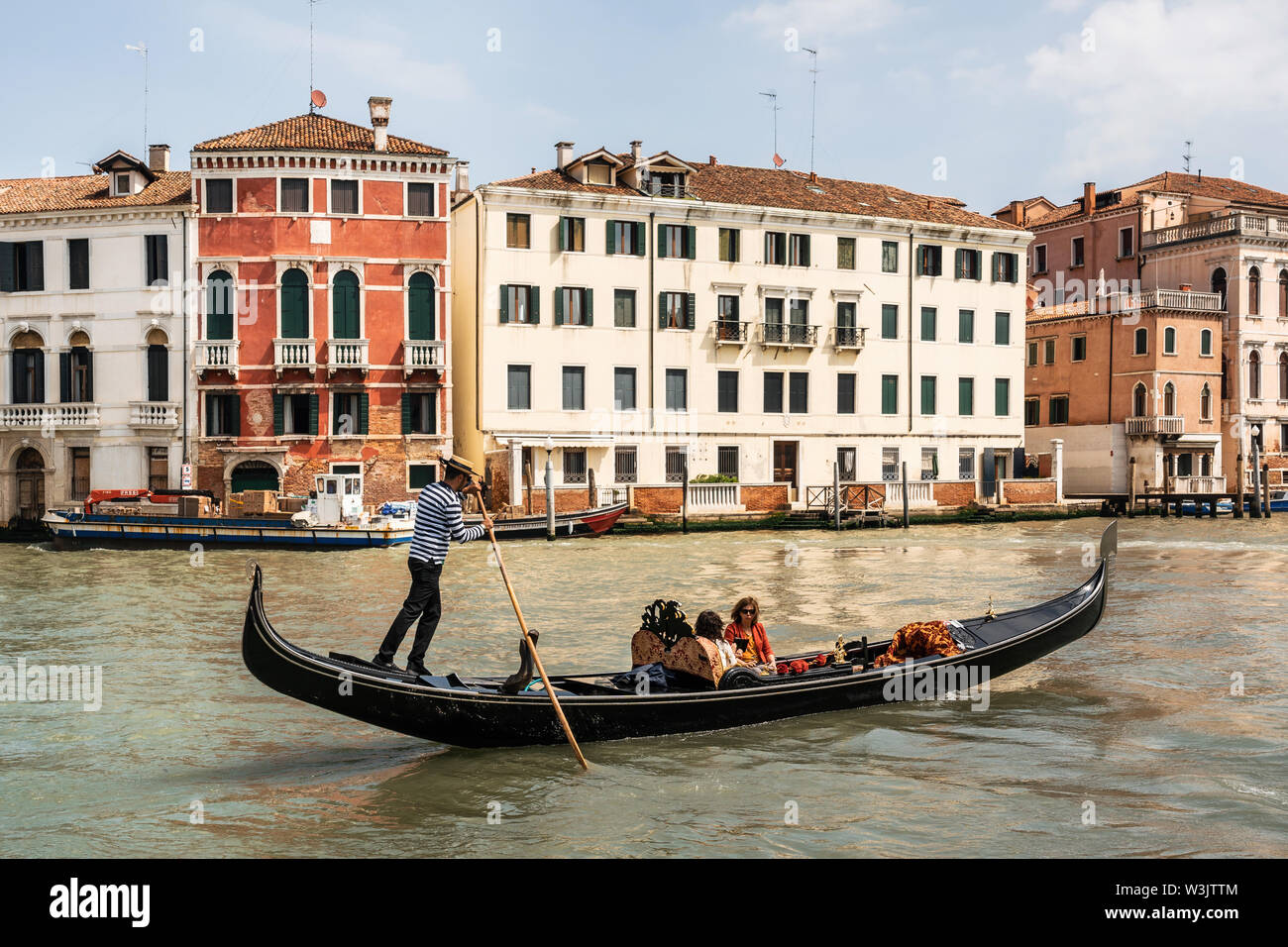 Venezia, Italia - 10 Maggio 2019: gondoliere veneziano sterline in gondola attraverso stretto canale Acque di Venezia Italia Foto Stock