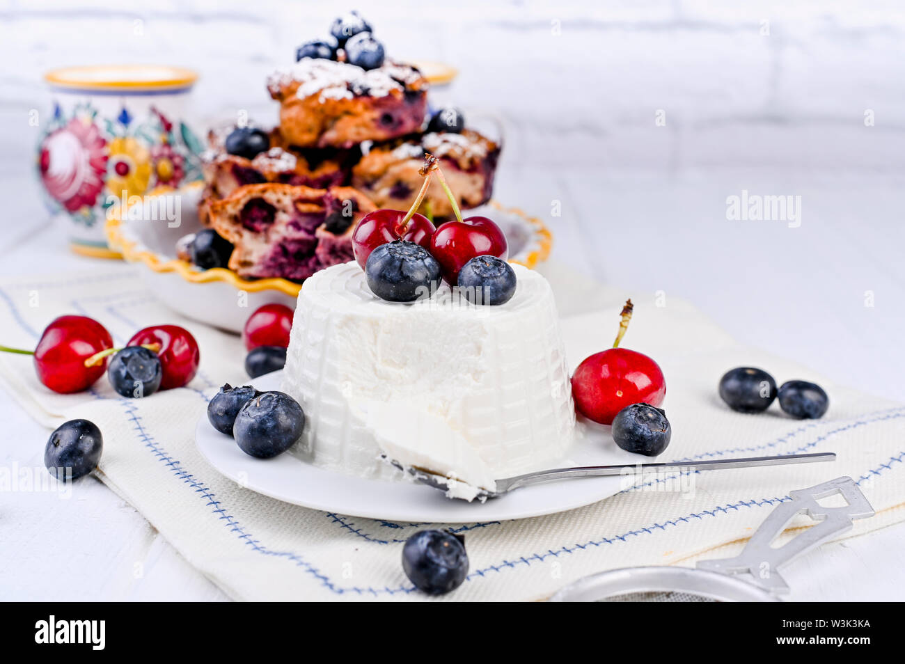 I dolci fatti in casa con ripieno di ricotta e frutti di bosco torta di formaggio per colazione. Il cibo italiano su uno sfondo bianco. Cottura sana e corretta nutrizione. Copia s Foto Stock