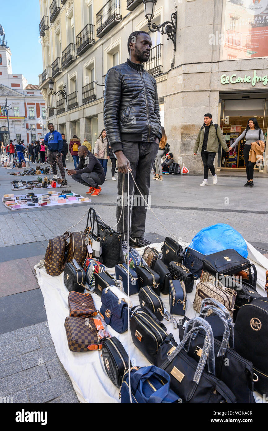 Gli immigrati counerfeit vendita merci sulle strade di Madrid vicino alla Puerta del Sol, centro di Madrid, Spagna. Foto Stock