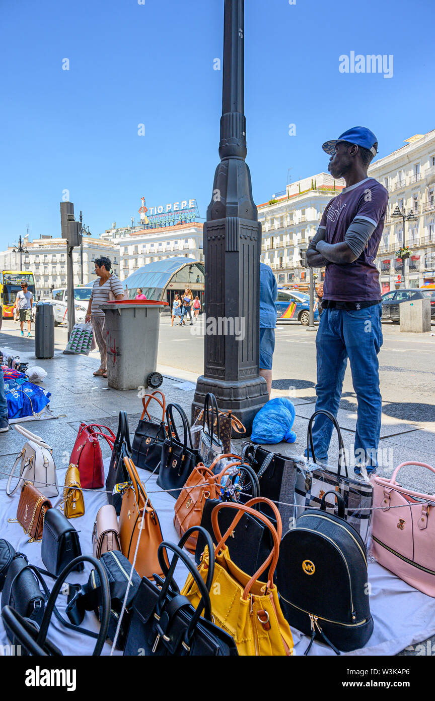Immigrato counerfeit vendita merci sulle strade di Madrid vicino alla Puerta del Sol, centro di Madrid, Spagna. Foto Stock