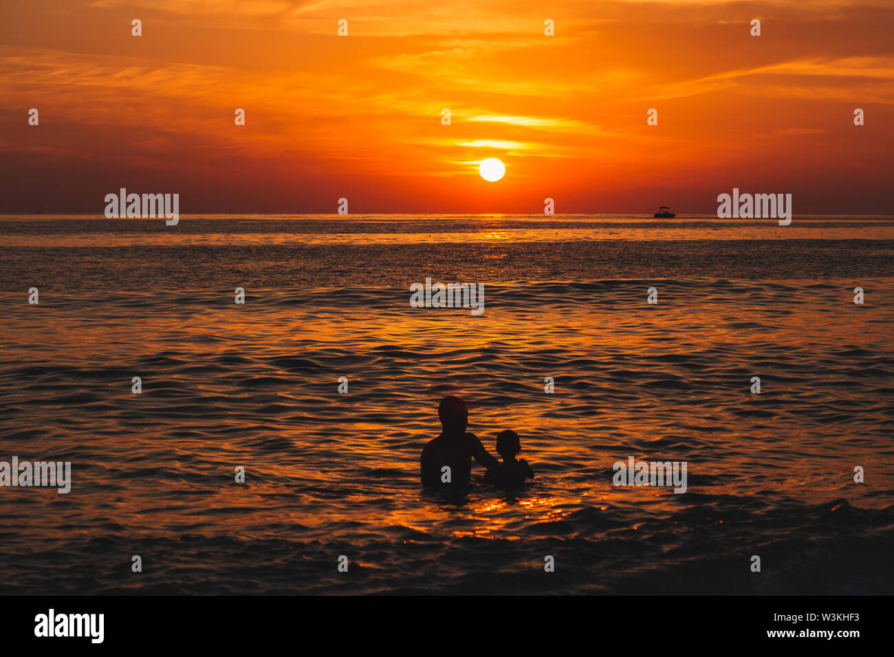 La gente di nuoto in mare al tramonto di sera, Cleopatra beach in Alanya, Turchia, distretto di Antalya Foto Stock