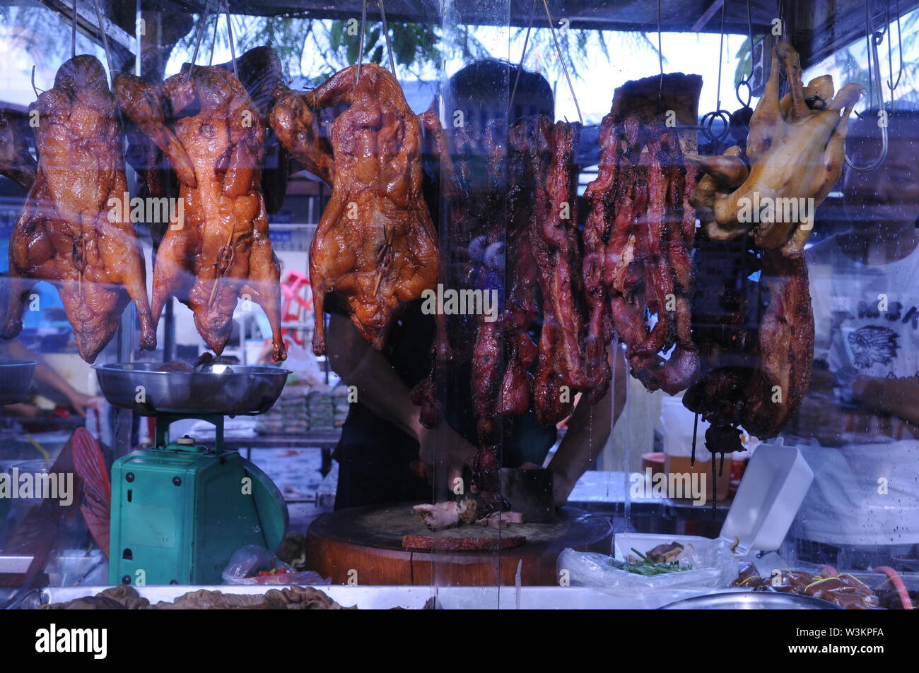 L anatra arrosto essendo sminuzzati, w/ una carne intelligente, da un venditore ambulante al mercato russo. Phnom Penh Cambogia. Credito: Kraig Lieb Foto Stock