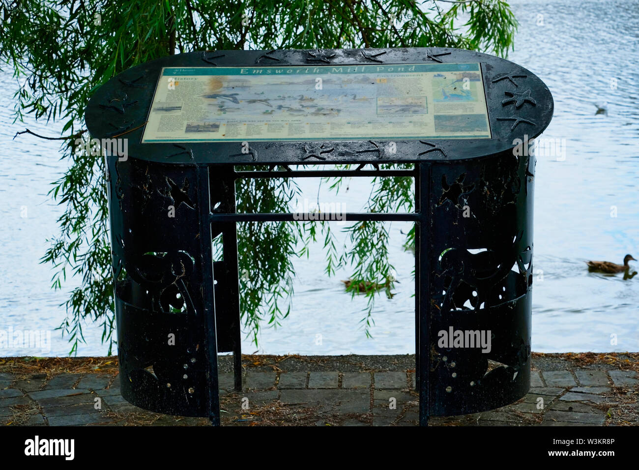 Informazioni turistiche board set in un bellissimo ferro battuto stand presso il bordo di Emsworth Mill Pond, Peschici, Hampshire, Regno Unito Foto Stock