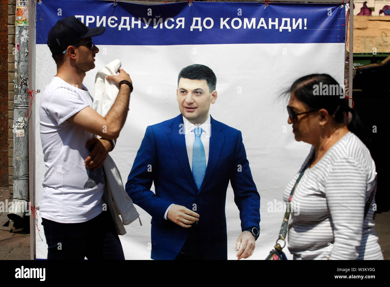 La gente a piedi passato una campagna elettorale poster ucraino di Primo Ministro Groysman Volodymyr di Kiev.L'inizio alle elezioni del Parlamento europeo avranno luogo in Ucraina il 21 luglio 2019. Secondo i sondaggi di opinione, sull'Ucraina 2019 elezioni parlamentari 5 parti sarà in grado di entrare in parlamento ucraino : il Presidente ucraino Volodymyr Zelensky partito chiamato servo del Popolo con il 41,5%, pro-russo piattaforma di opposizione - per la vita con il 12,5%, parte vocale della Ukrainian rock star Svyatoslav Vakarchuk con 8,8%, la solidarietà europea dell ex Presidente ucraino Petro Poroshenko con 8 Foto Stock La gente a piedi passato una campagna elettorale poster ucraino di Primo Ministro Groysman Volodymyr di Kiev.L'inizio alle elezioni del Parlamento europeo avranno luogo in Ucraina il 21 luglio 2019. Secondo i sondaggi di opinione, sull'Ucraina 2019 elezioni parlamentari 5 parti sarà in grado di entrare in parlamento ucraino : il Presidente ucraino Volodymyr Zelensky partito chiamato servo del Popolo con il 41,5%, pro-russo piattaforma di opposizione - per la vita con il 12,5%, parte vocale della Ukrainian rock star Svyatoslav Vakarchuk con 8,8%, la solidarietà europea dell ex Presidente ucraino Petro Poroshenko con 8 Foto Stock