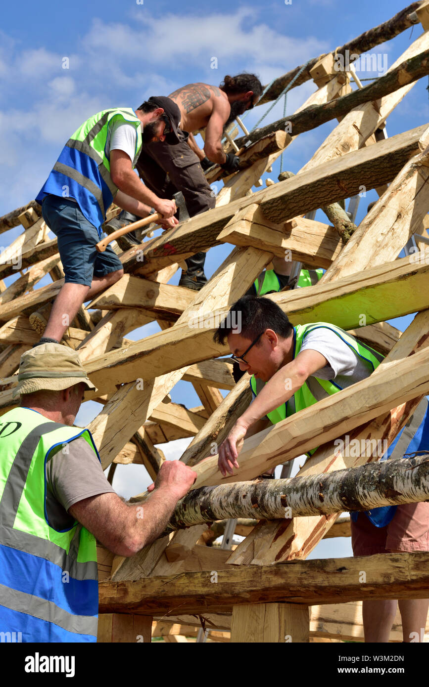 Carpentieri di lavoro sul tetto della costruzione di nuova costruzione medievale tradizionale Anglo Sassone con cornice in legno edificio Foto Stock
