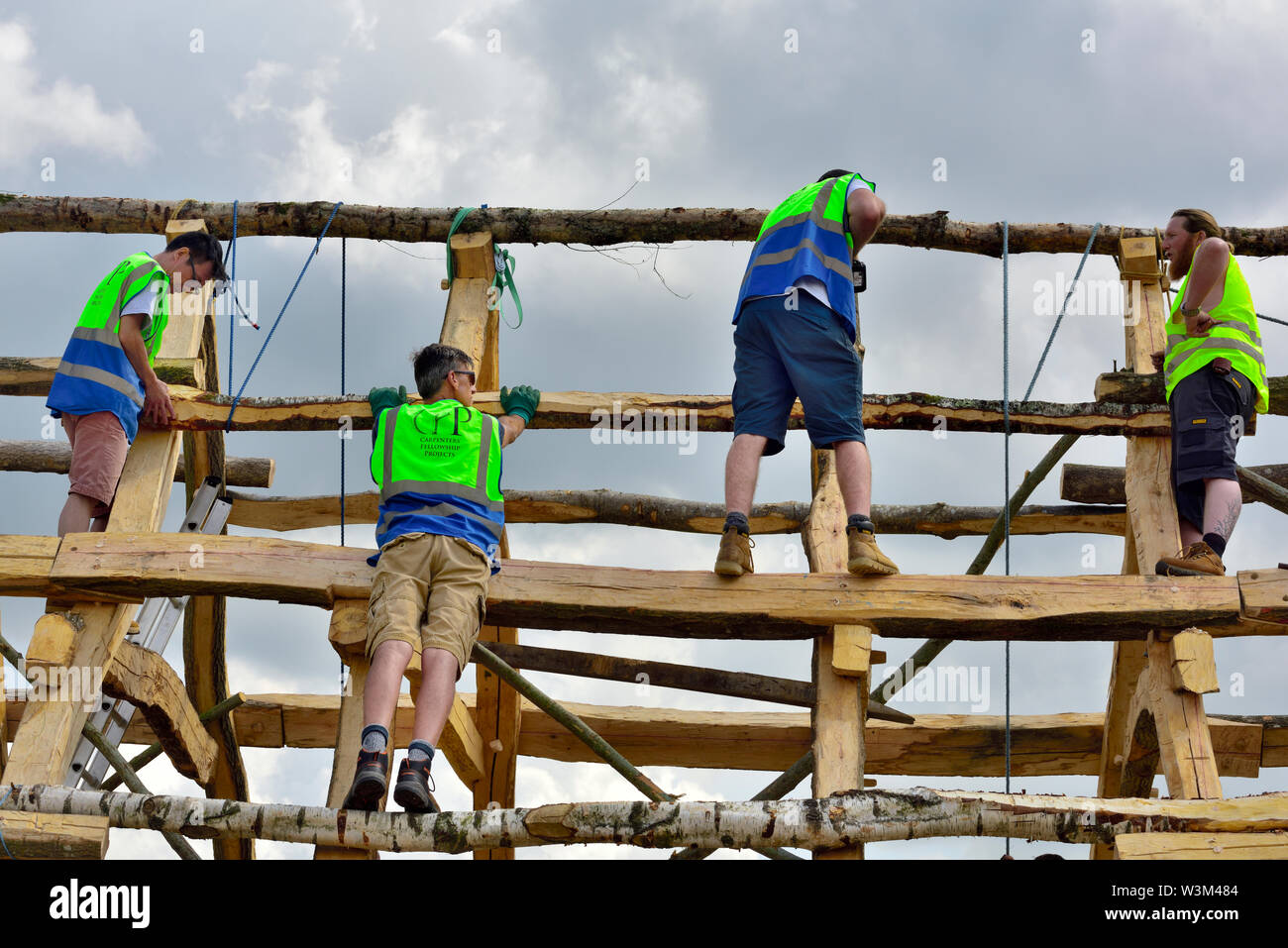 Posizionamento di travi di legno in una nuova riproduzione medievale tradizionale Anglo Sassone con cornice in legno di quercia hall edificio utilizzando i metodi tradizionali, REGNO UNITO Foto Stock