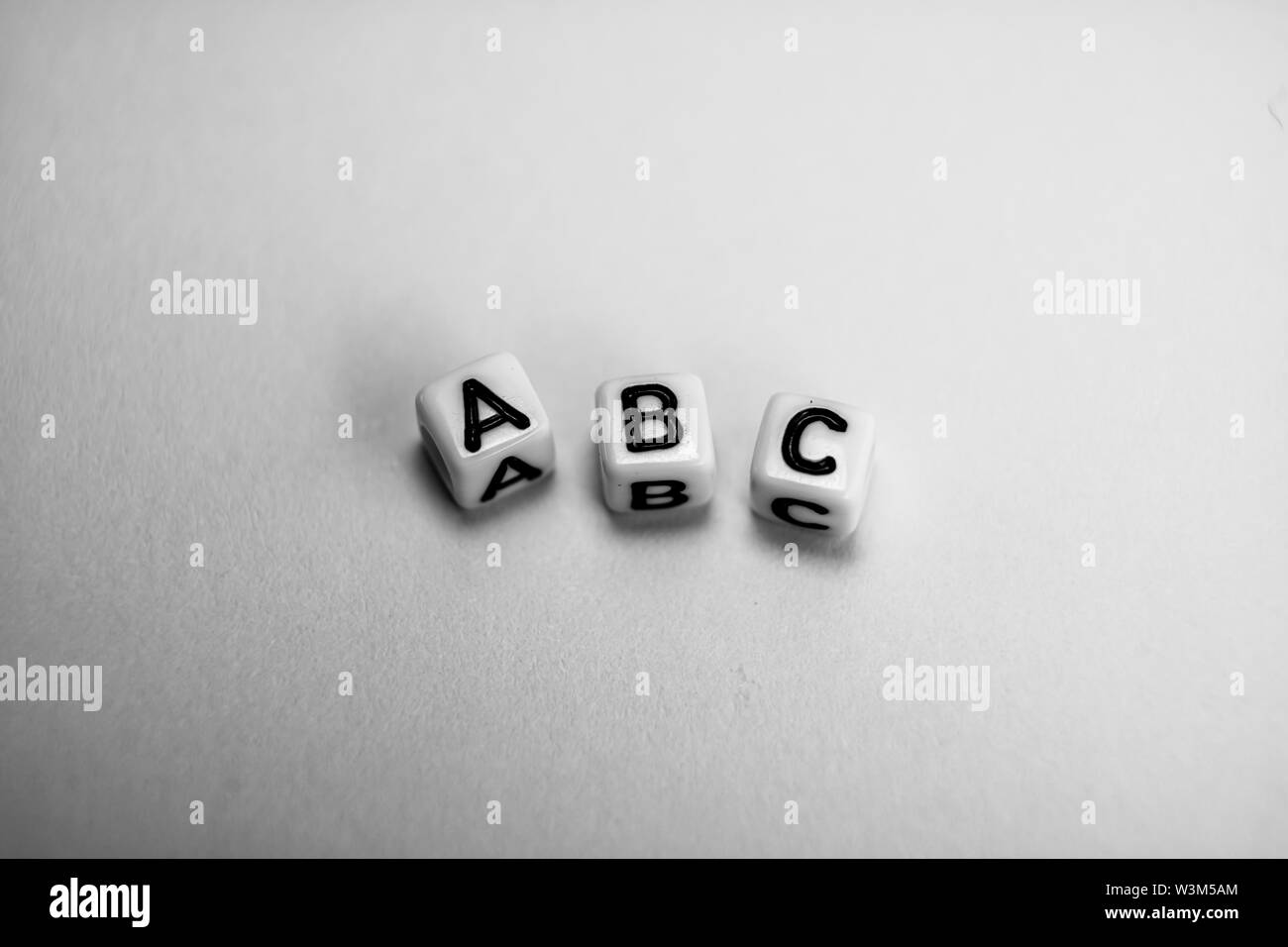 Cubi di bianco con la parola ABC su carta bianca di sfondo e ombre scure Foto Stock