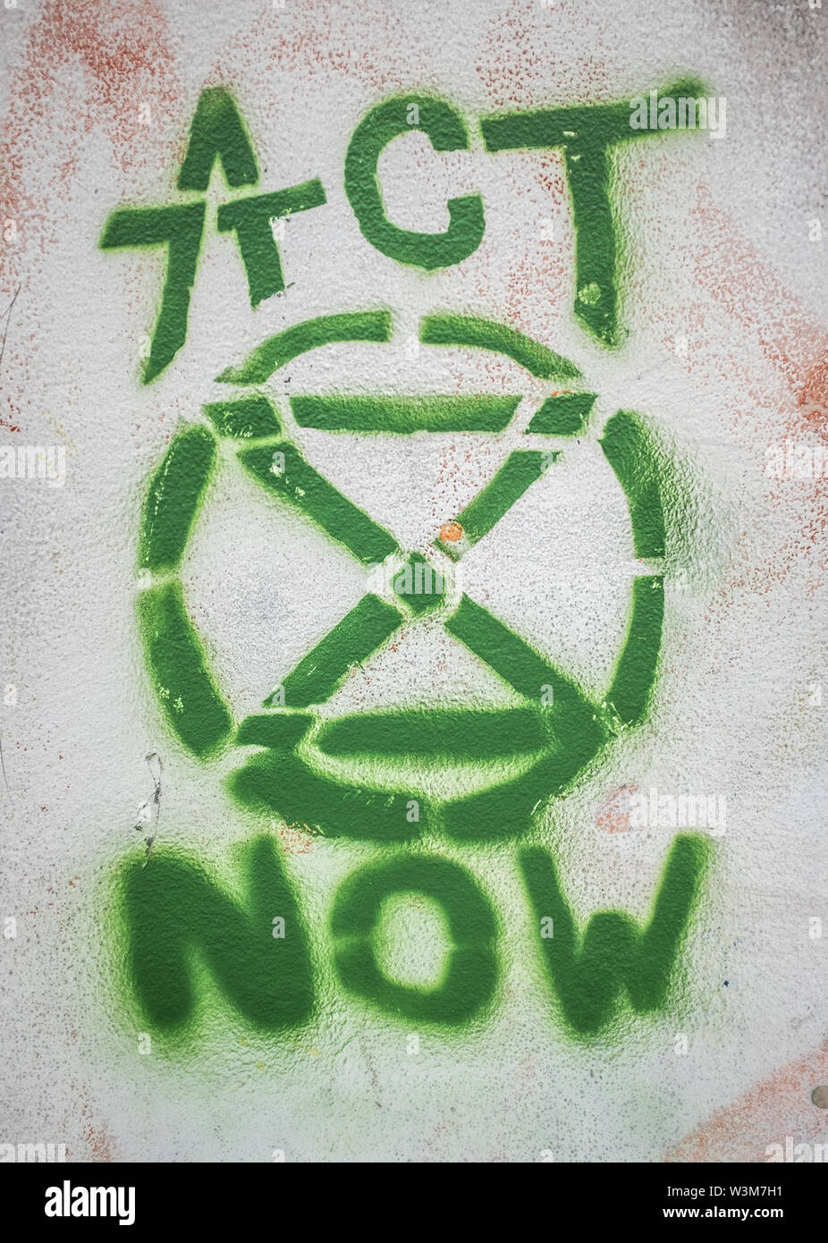 LONDON, Regno Unito - 16 luglio 2019: Graffiti di estinzione di ribellione e il logo "agire ora' Slogan su una parete durante la protesta Graffiti di estinzione della ribellione Logo Foto Stock