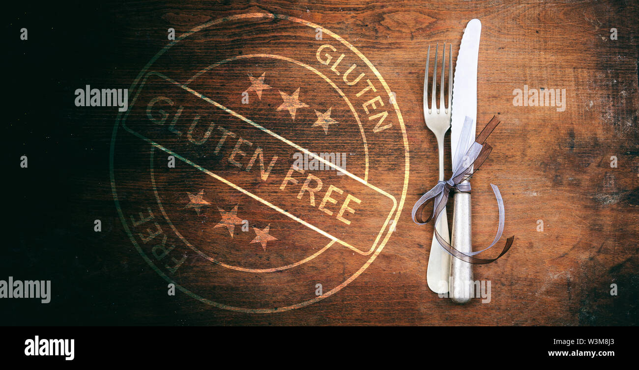 Senza glutine menu certificata, mangiare sano concetto. Esente da glutine timbro e set di posate su tavola in legno rustico, vista dall'alto. Foto Stock