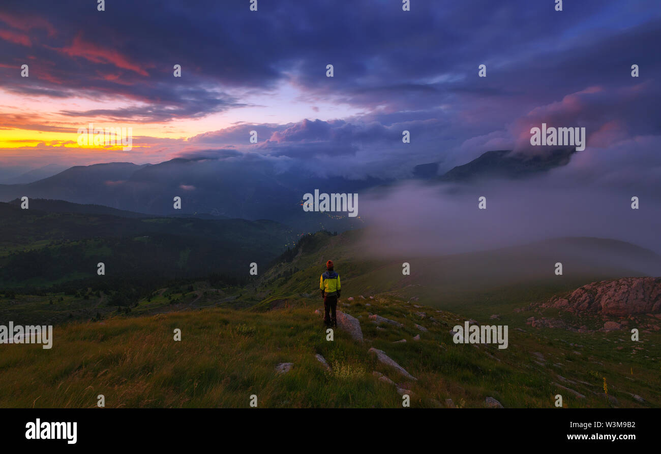 Scalatore tra le montagne di nebbia Foto Stock