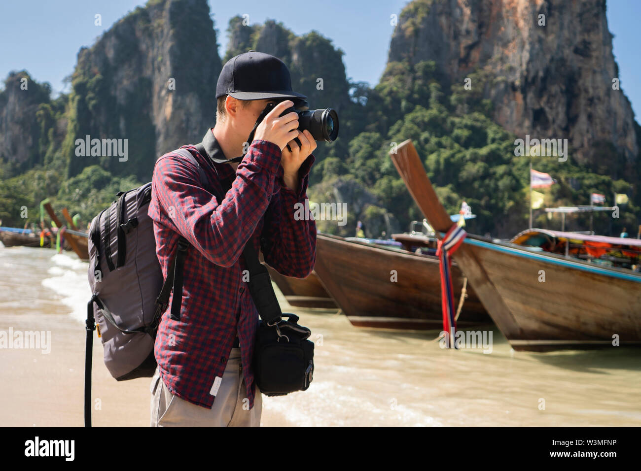 Giovane uomo fotografare sulla spiaggia di Krabi, in Thailandia Foto Stock