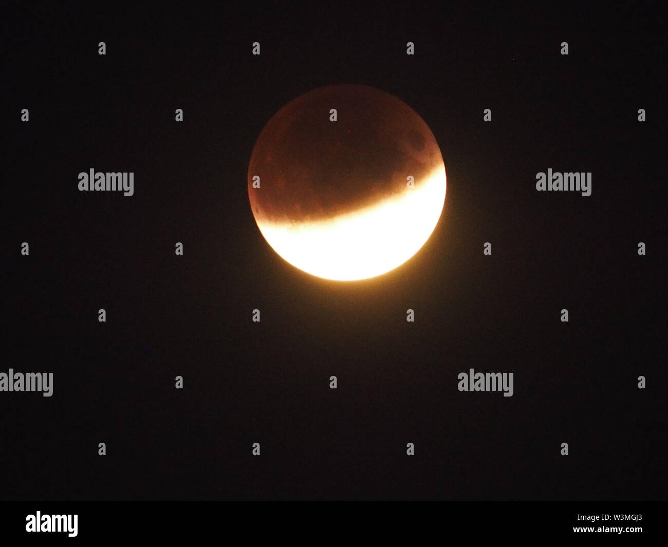 Sheerness, Kent, Regno Unito. 16 Luglio, 2019. Regno Unito: Meteo le eclissi lunare parziale come sopra visto Sheerness nel Kent vicino al 22.30. Credito: James Bell/Alamy Live News Foto Stock