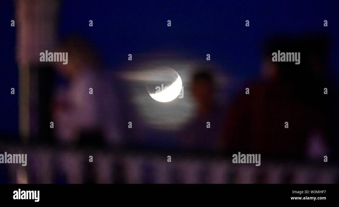 Brighton Regno Unito 16 luglio 2019 - martedì notte ballerini in Brighton bandstand con l'Eclissi lunare parziale del luglio Buck Luna dietro sul cinquantesimo anniversario dell'Apollo 11 lancio sulla sua missione verso la luna in1969 Credit: Simon Dack / Alamy Live News Foto Stock