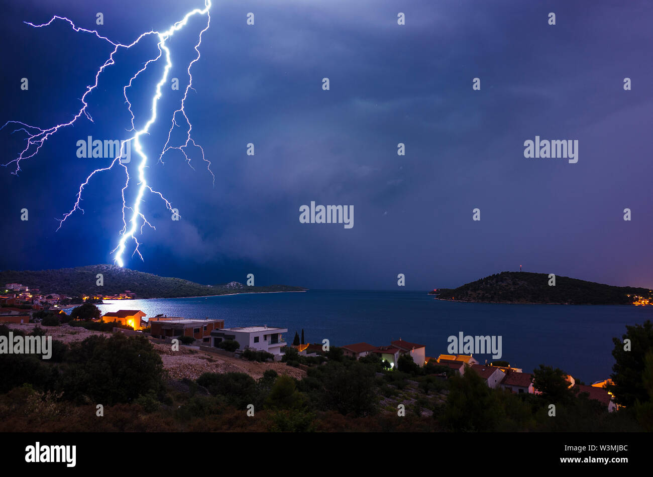 Nuvole temporalesche e tempo duro oltre il mare Adriatico in Croazia Europa. Potente e fulmine lampeggia sopra il villaggio Rogoznica in costa dalmata. Foto Stock