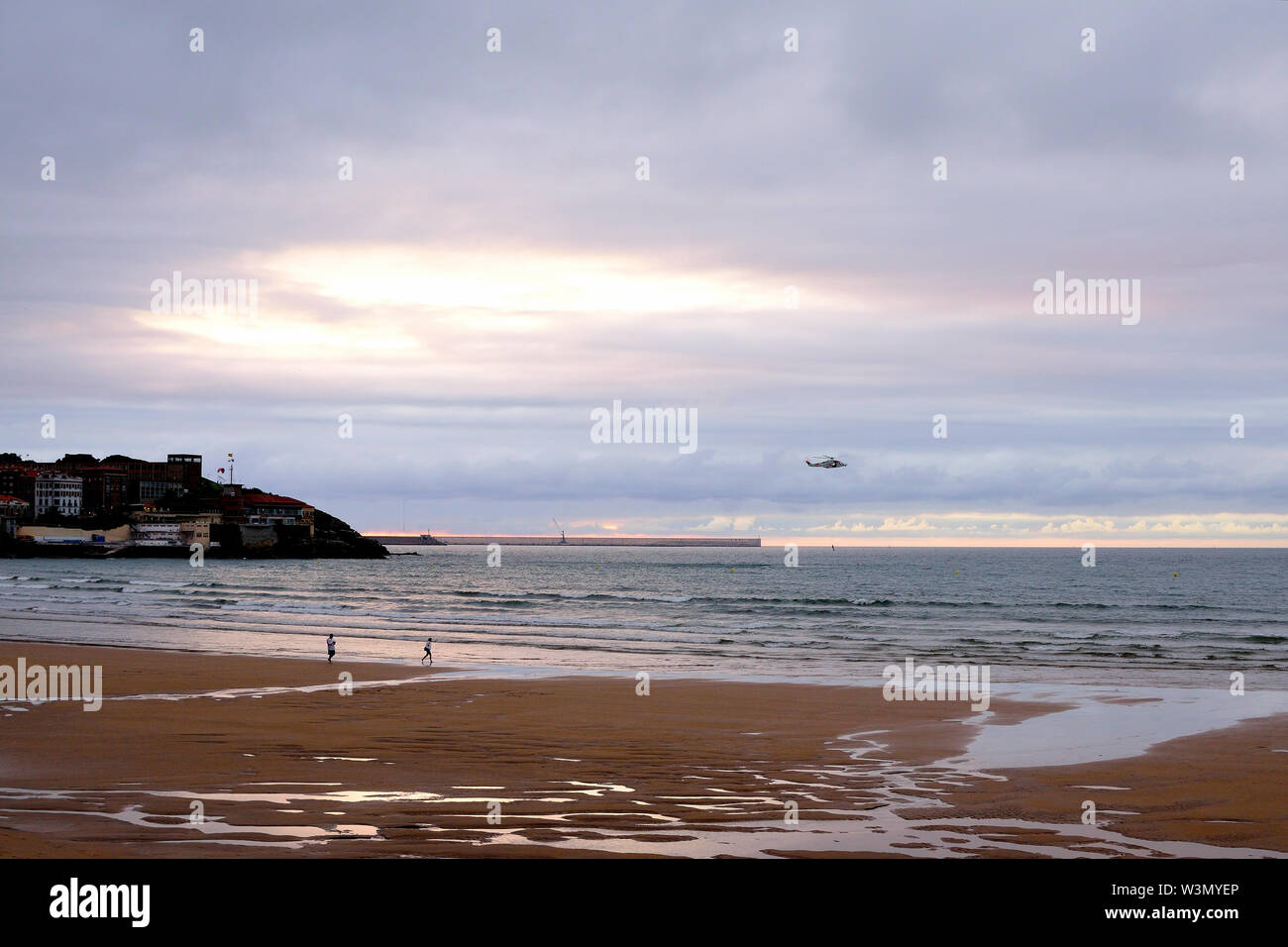 Al atardecer se dibujan luces en el lienzo de la playa de San Lorenzo. Foto Stock