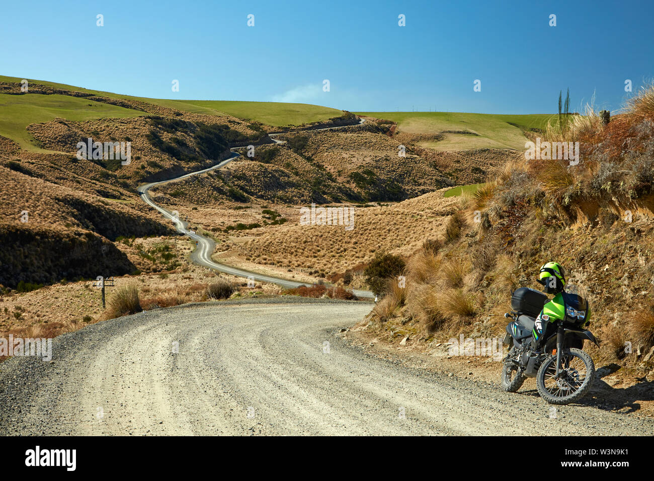 Avventura e moto strada attraverso tussocks, vicino al lago di Mahinerangi, Otago, Isola del Sud, Nuova Zelanda Foto Stock