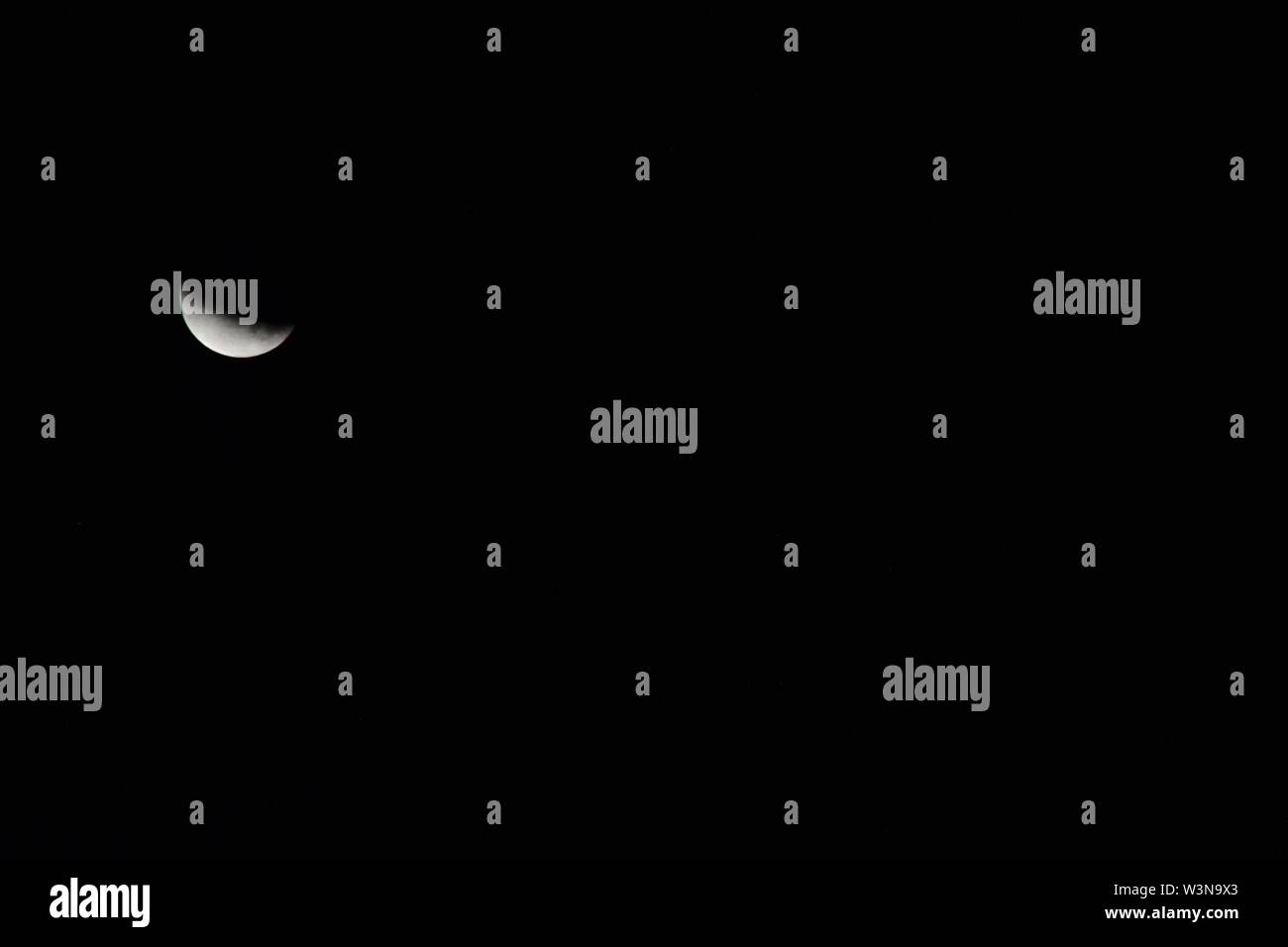 La questione del Kashmir, India. 17 Luglio, 2019. La luna può essere visto durante un'Eclissi lunare parziale in Srinagar. Skywatchers in tutto il mondo hanno testimoniato una Eclissi lunare parziale, 50 anni al giorno dato che la missione di noi per portare gli uomini sulla Luna sollevata. L'eclipse ha iniziato a partire dal 1:31 am il 17 luglio. Il numero massimo di eclipse si è verificato alle 3 del mattino e le eclissi parziale si è conclusa a 4:29 am in India. Questa è stata l'ultima eclissi lunare dell'anno 2019. Credito: SOPA Immagini limitata/Alamy Live News Foto Stock