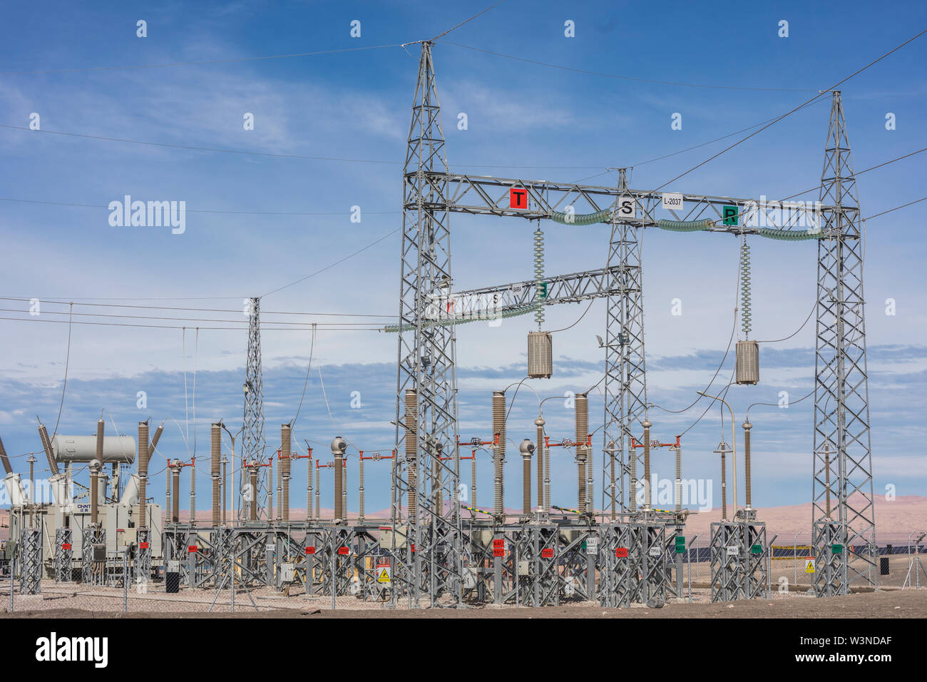 Le linee di alimentazione e Susbstations nel mezzo del deserto per la generazione di energia da fonti rinnovabili Foto Stock