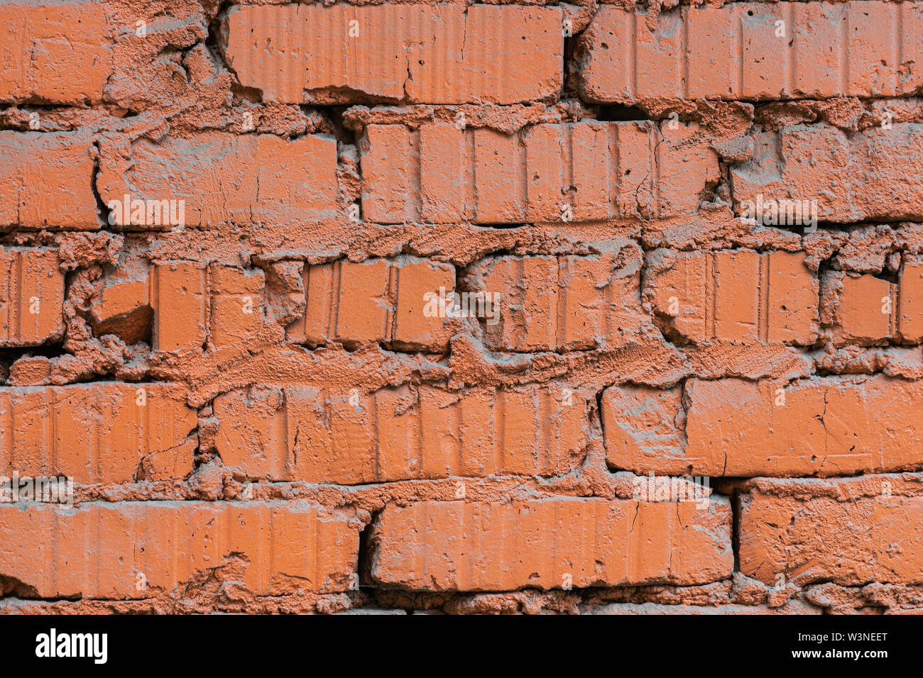 Vista ingrandita di un grunge muro in mattoni dipinti con vernice di colore arancione. Texture di sfondo o per un progetto Foto Stock