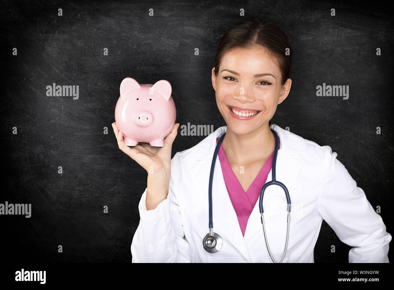 Assicurazione medica e sanitaria concetto di denaro. Medico donna donna azienda mostra salvadanaio sorridendo felice indicante il risparmio. Giovane medico professionista medico sulla lavagna sfondo. Foto Stock